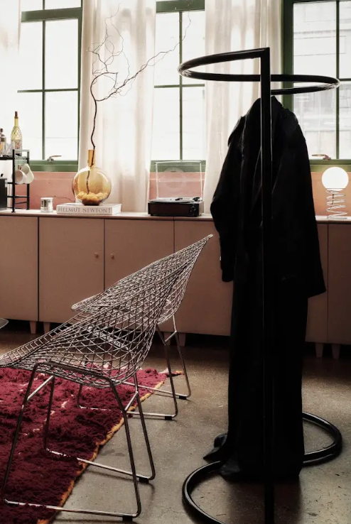 Wire chairs and coat rack in the studio's soft daylight